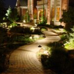 A walkway lit up at night in front of a house.