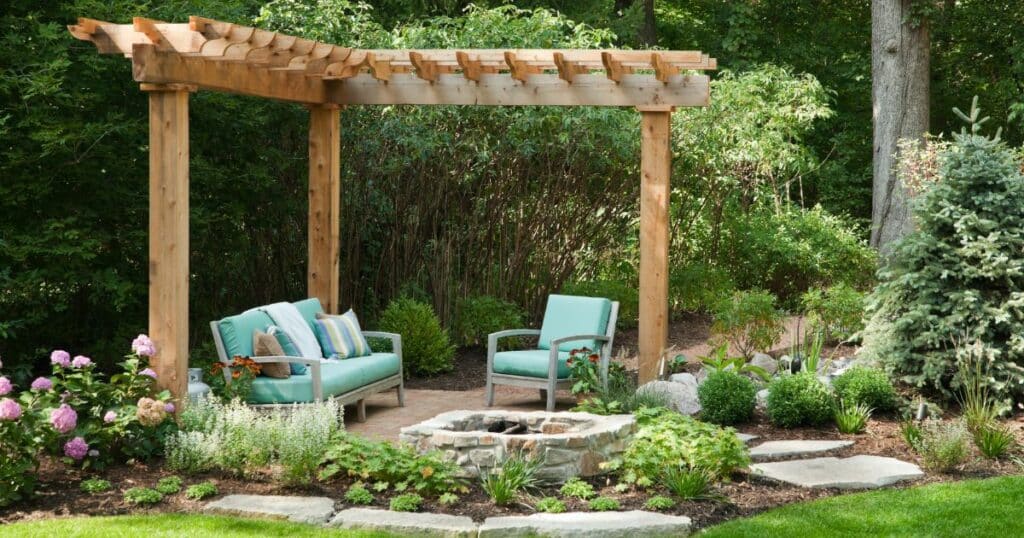 A backyard with a wooden pergola and a fire pit.