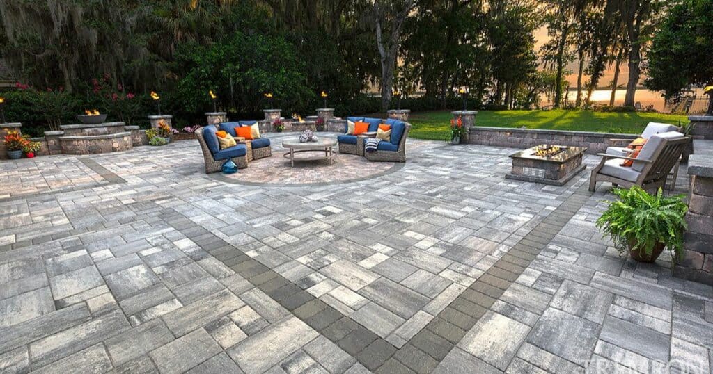A patio with a fire pit and chairs. 