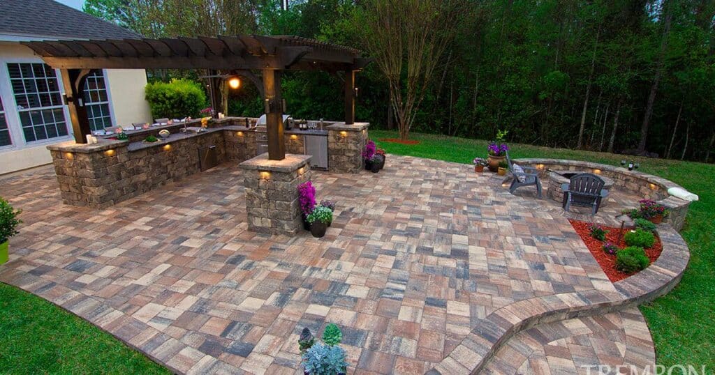 A backyard with a brick patio and grill. 