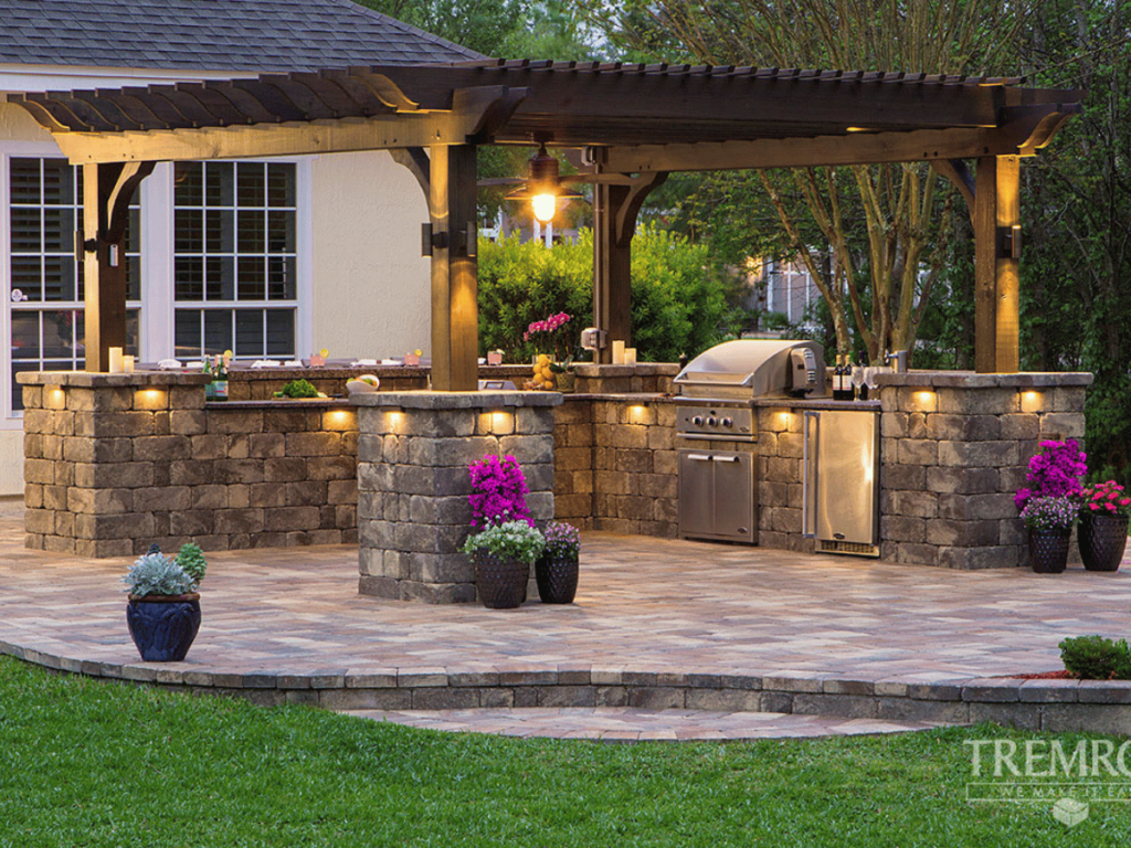 An outdoor kitchen with a pergola designed by a landscape design company