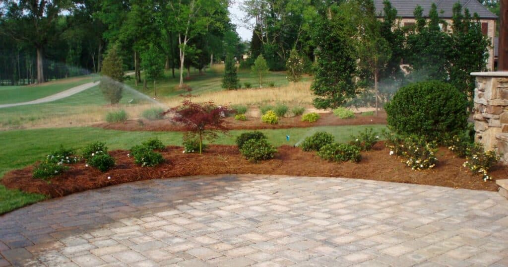 A brick paver patio with a sprinkler irrigation system.
