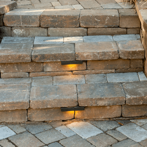 Stone steps with built-in under-step lighting on an outdoor walkway.