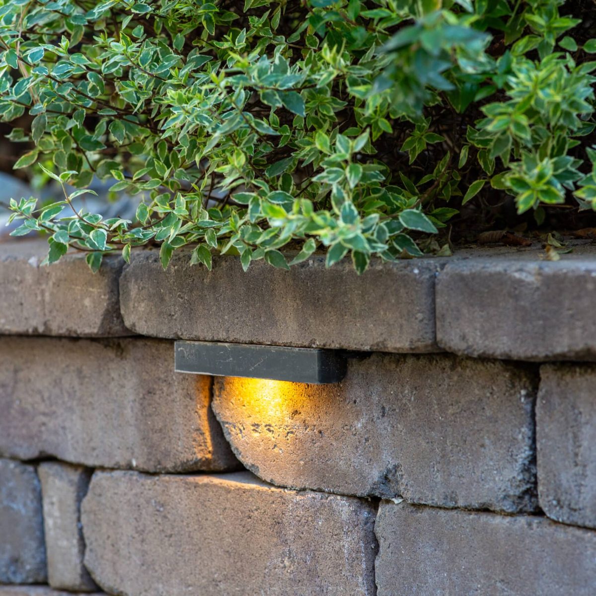 A stone wall with a light on it.